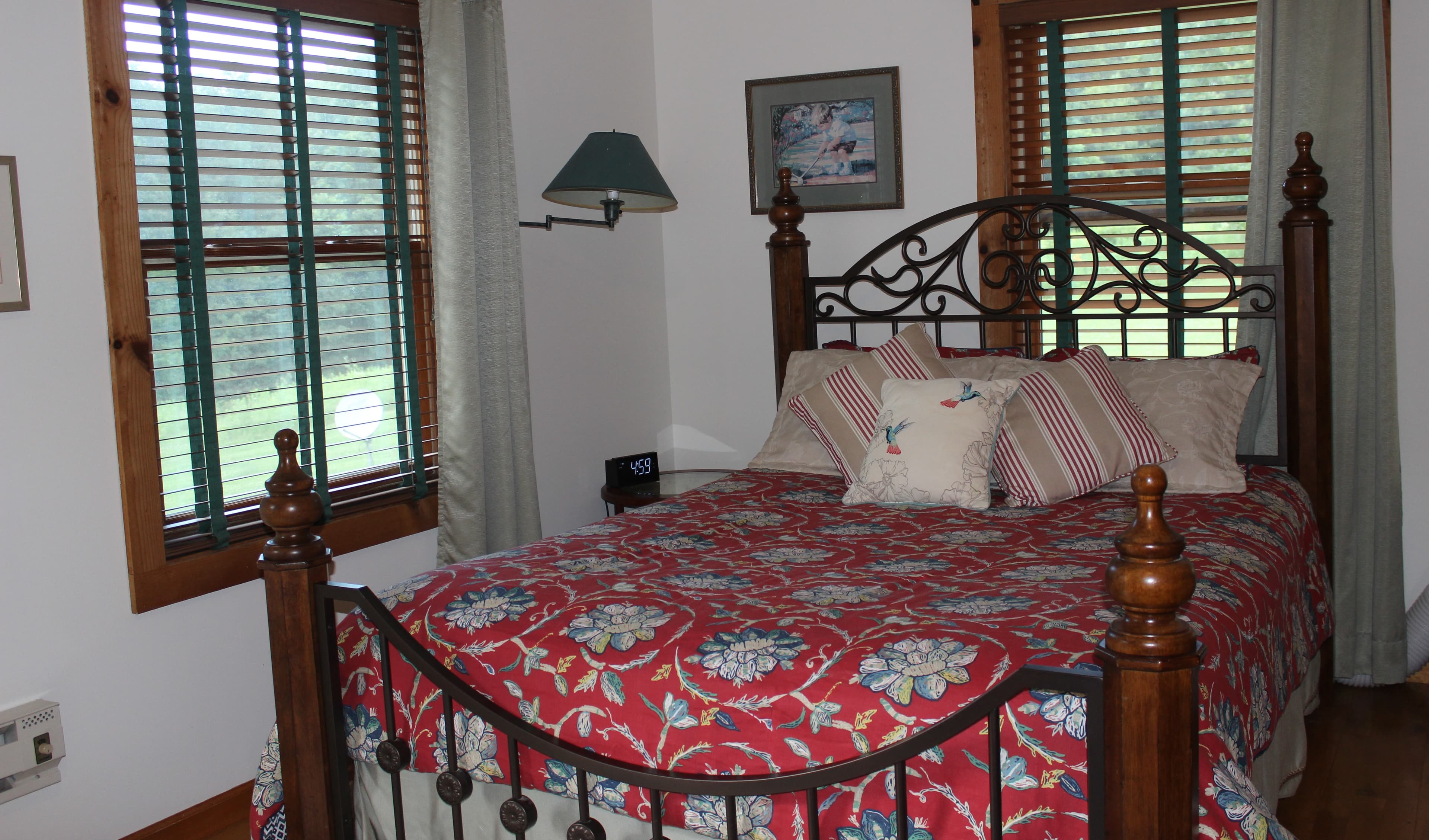 Wheelchair accessible corner room on the main level means no stairs!  Beautiful queen sized bed covered with red floral comforter.