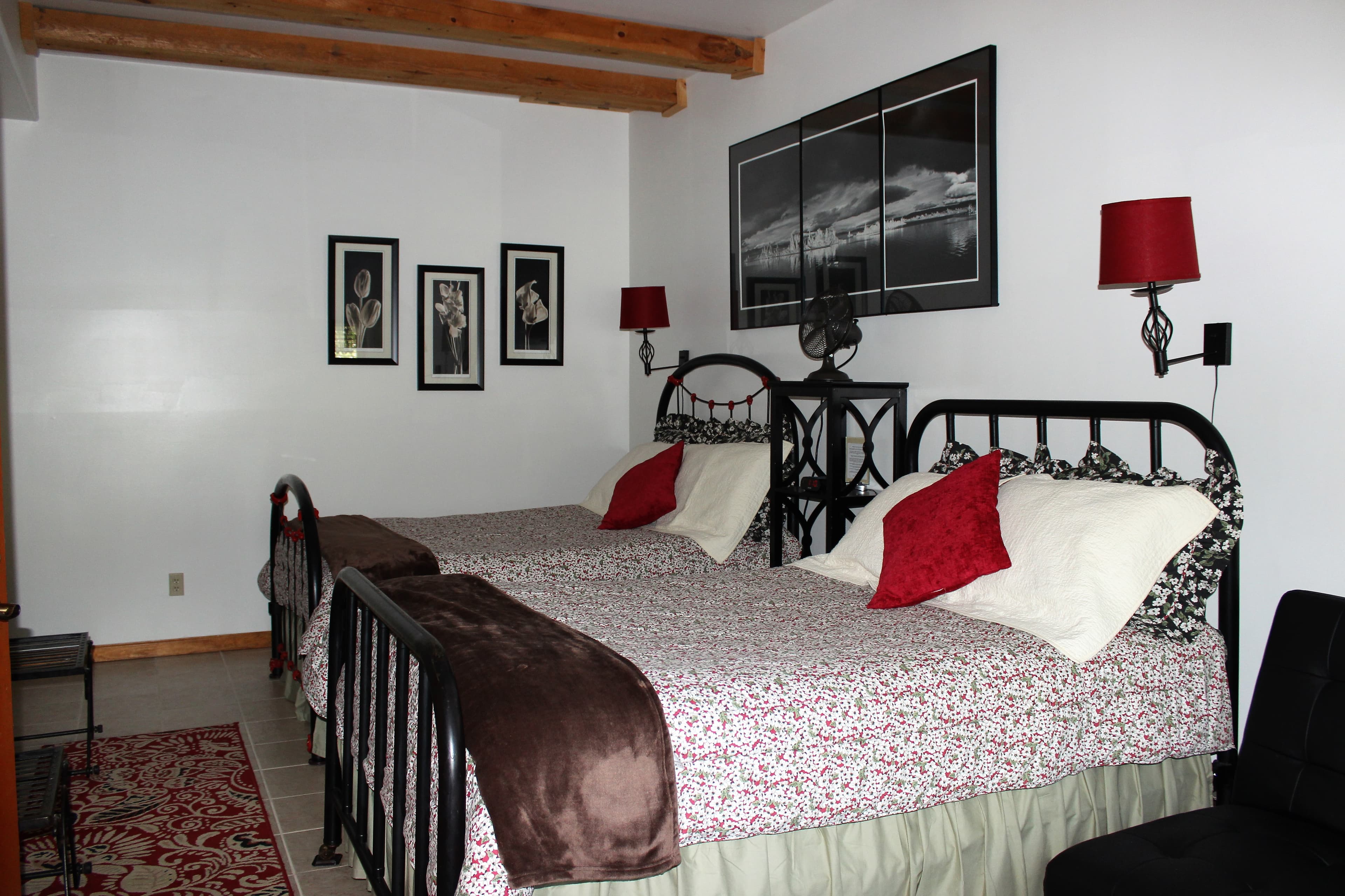 2 iron framed full-sized beds covered in floral comforters.