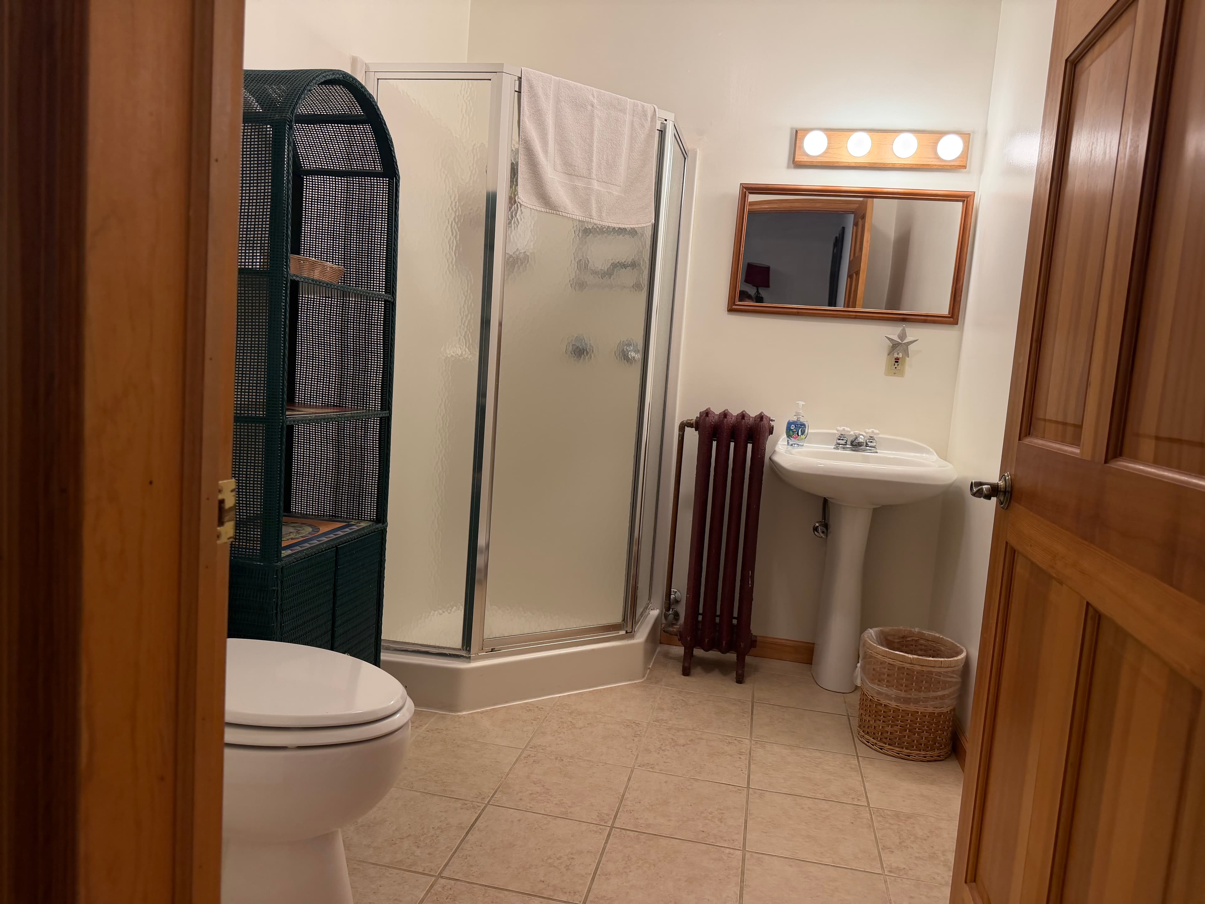 A clean bathroom featuring a shower, sink, toilet, and towel rack.